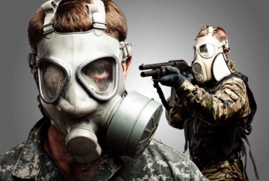 young soldiers wearing gas mask over grey background