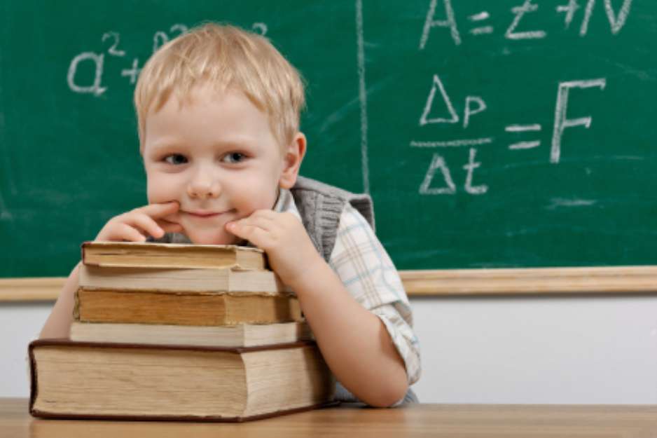 Cheerful smiling   child resting on a stack of books