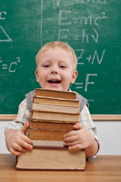 Cheerful smiling  little boy sitting at the table.