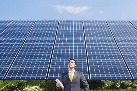 businessman standing near solar panels