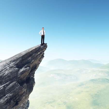 Businessman standing on a peak