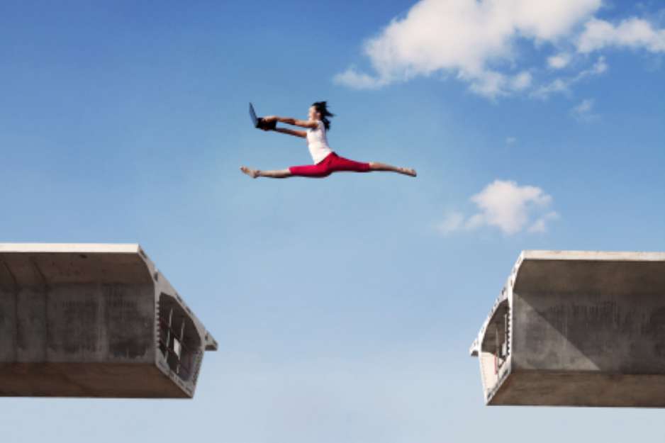 Attractive woman jumping with laptop