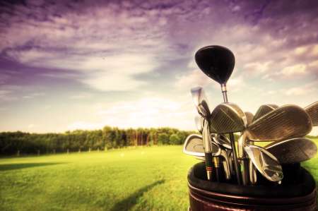Golf gear, clubs at sunset on golf course