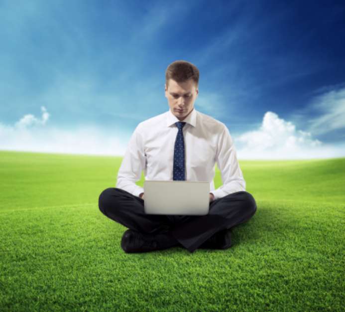 business man with notebook sitting on grass