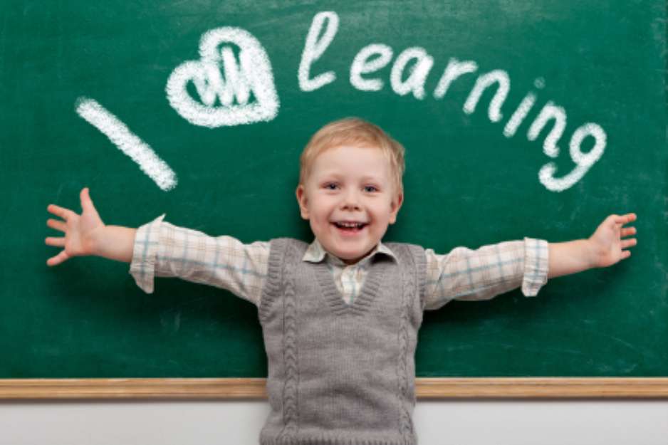 Cheerful smiling child at the blackboard.
