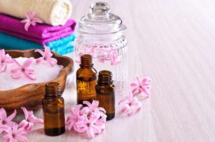 Aromatic oil for Spa in a glass vial surrounded by flowers pink hyacinth.