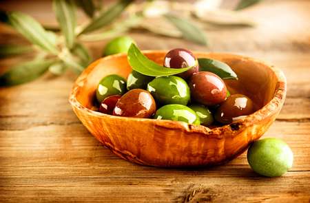 Olives and Olive Oil on the wooden table