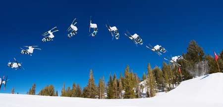 Sequence of a Skier doing a Radical Back flip on a Sunny Day at a Ski resort