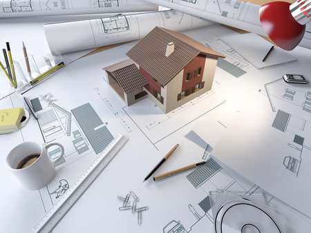 drawing table of an architect with plans and 3d model of a house