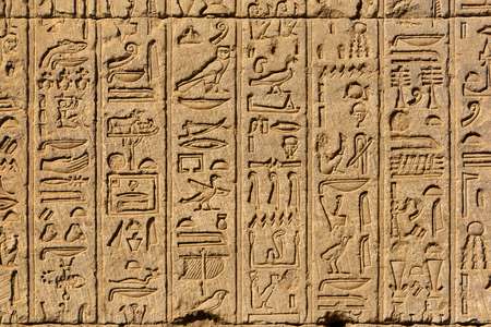 Hieroglyphic carvings on the exterior walls of an ancient egyptian temple 