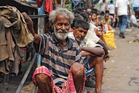CALCUTTA - APRIL 13: Poor and jobless men waiting on the street for a job on April 13, 2014 in Calcutta, India. India has the lar