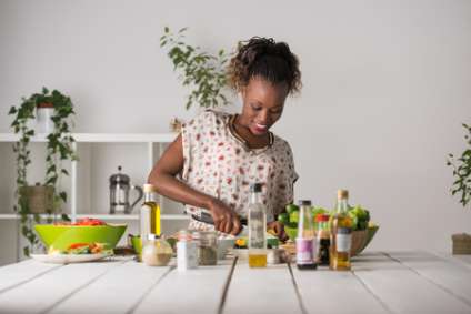 Young African Woman Cooking. Healthy Food - Vegetable Salad. Diet. Dieting Concept. Healthy Lifestyle. Cooking At Home. Prepare Food