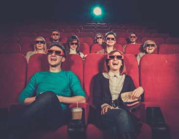 Group of people in 3D glasses watching movie in cinema